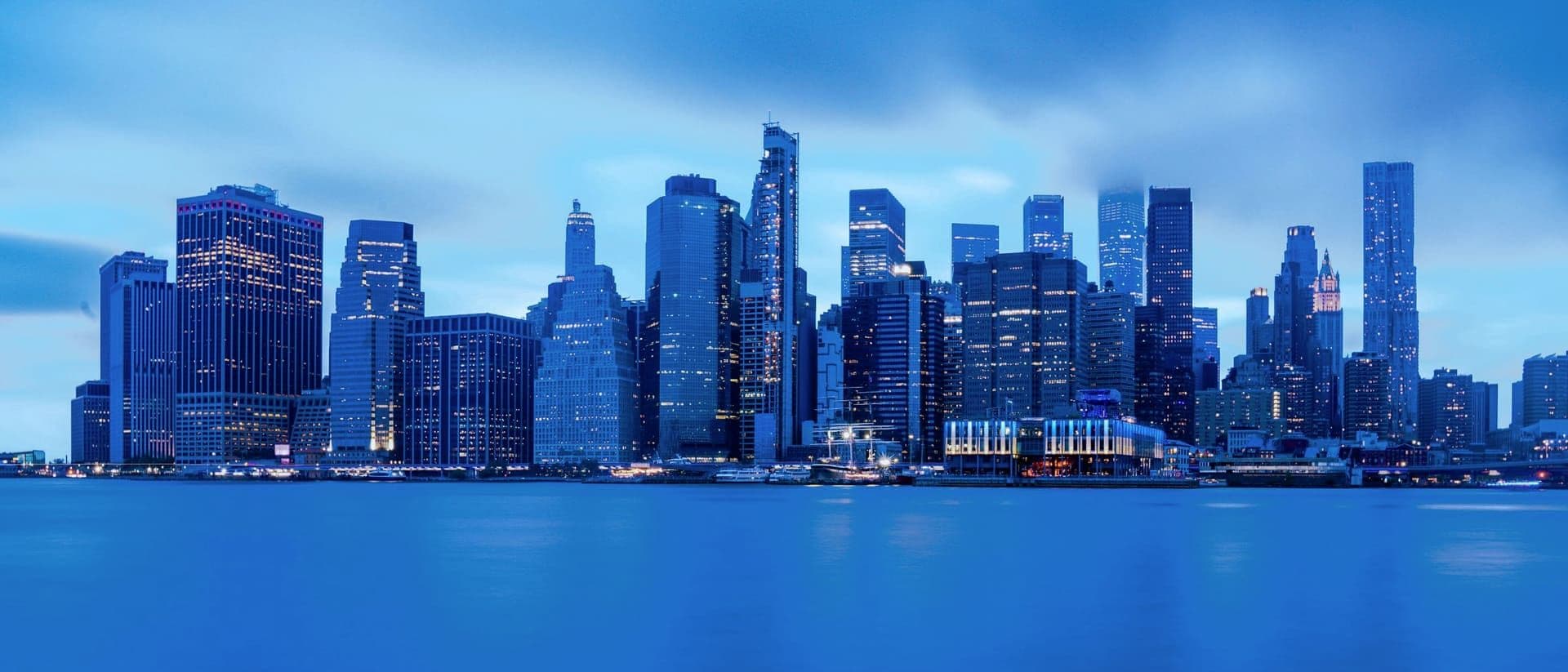 Lower Manhattan skyline at blue hour, viewed across the East River